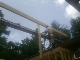 Carpenter setting a ridge beam over a new addition frame — Ice Dam Removal by Roofing Brothers in Woodlake