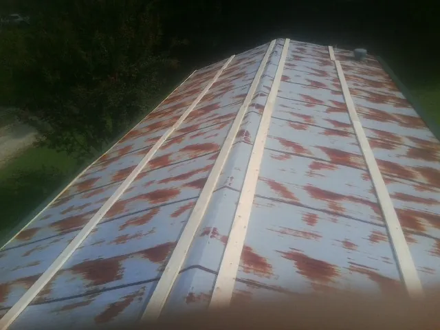 Rusted metal roof panels with new wood purlins before replacement — Storm Damage Roof Repair in Woodlake by Roofing Brothers