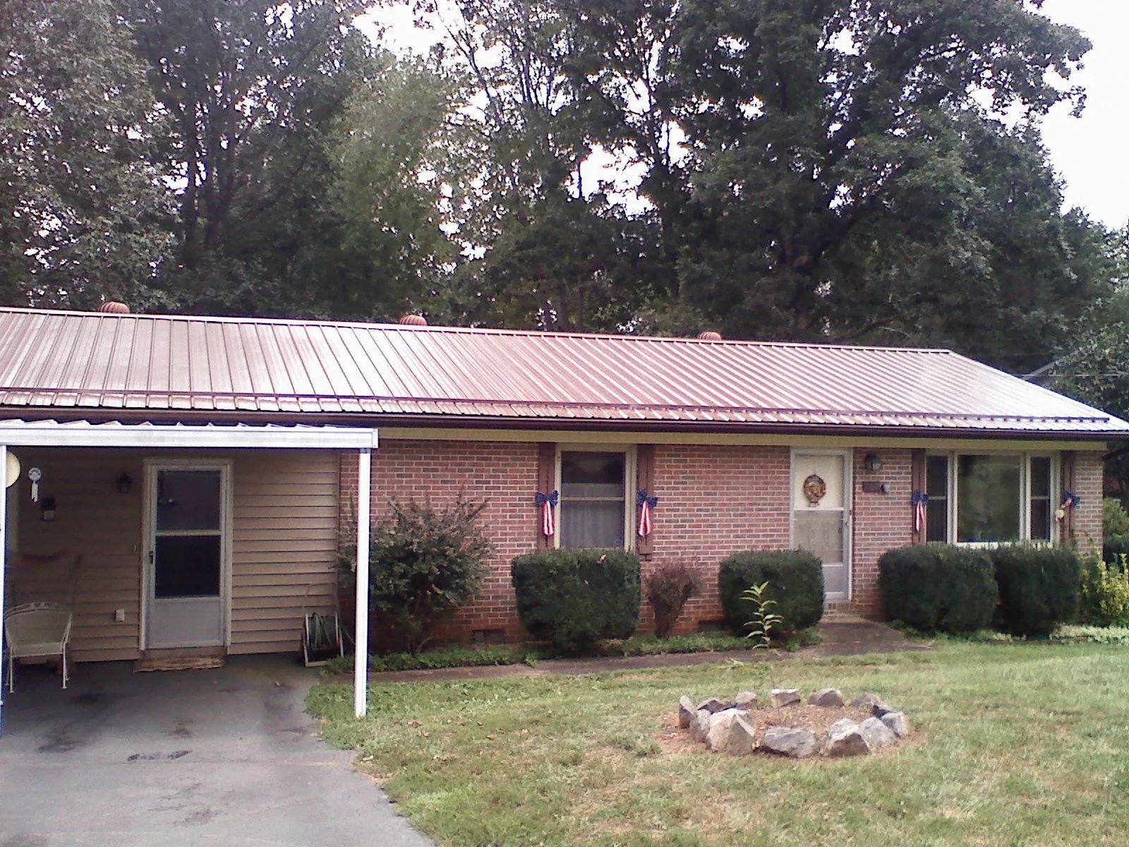 Bronze metal roof and carport on a brick ranch home — Roof Repair work by our crew in Woodlake